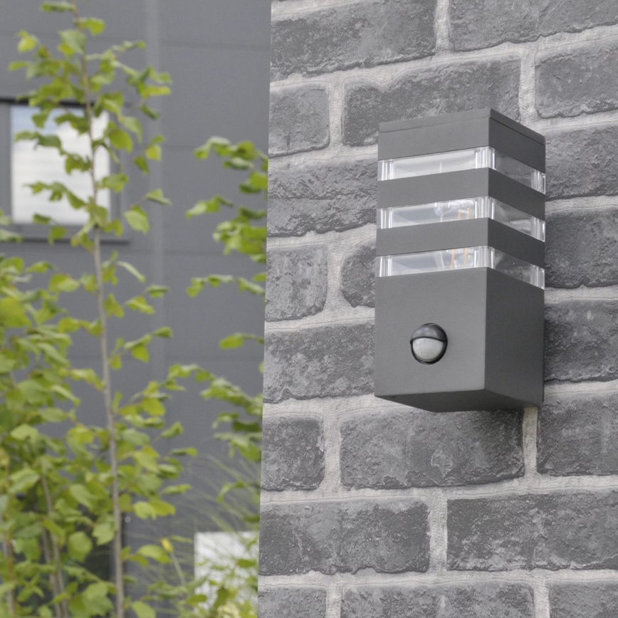 Εξωτερικό επιτοίχιο φωτιστικό με αισθητήρα TEKSAS 1xE27/12W/230V IP44 ανθρακί