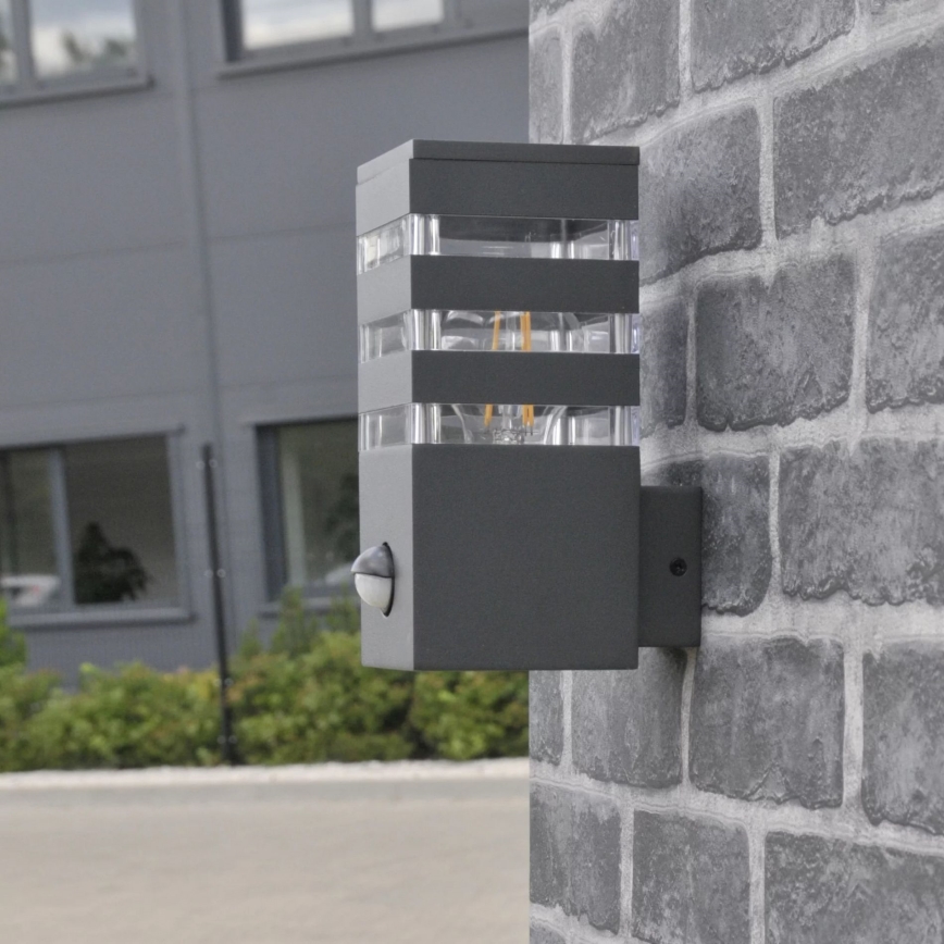 Εξωτερικό επιτοίχιο φωτιστικό με αισθητήρα TEKSAS 1xE27/12W/230V IP44 ανθρακί