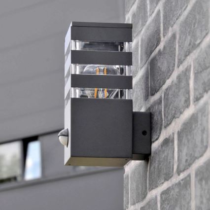 Εξωτερικό επιτοίχιο φωτιστικό με αισθητήρα TEKSAS 1xE27/12W/230V IP44 ανθρακί